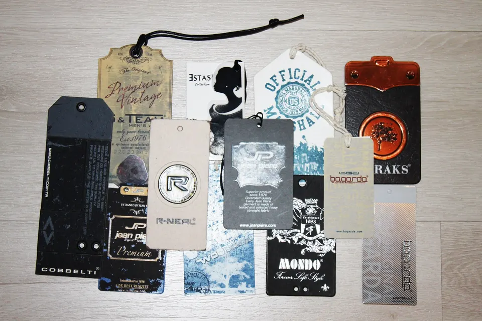 Kraft, black, white and copper-foil hang tags with strings on a wooden table