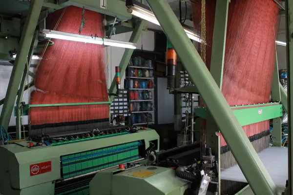 Weaving loom with colourful yarn cones