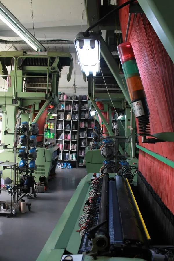 Woven label production line with looms and yarn shelves